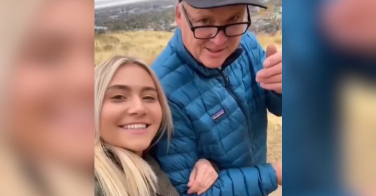 A woman takes a walk with her dad on a scenic trail.