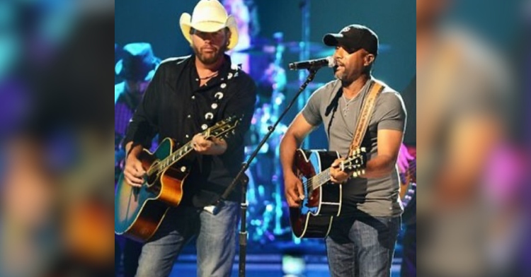 Throwback photo of Darius Rucker and Toby Keith performing on stage together.