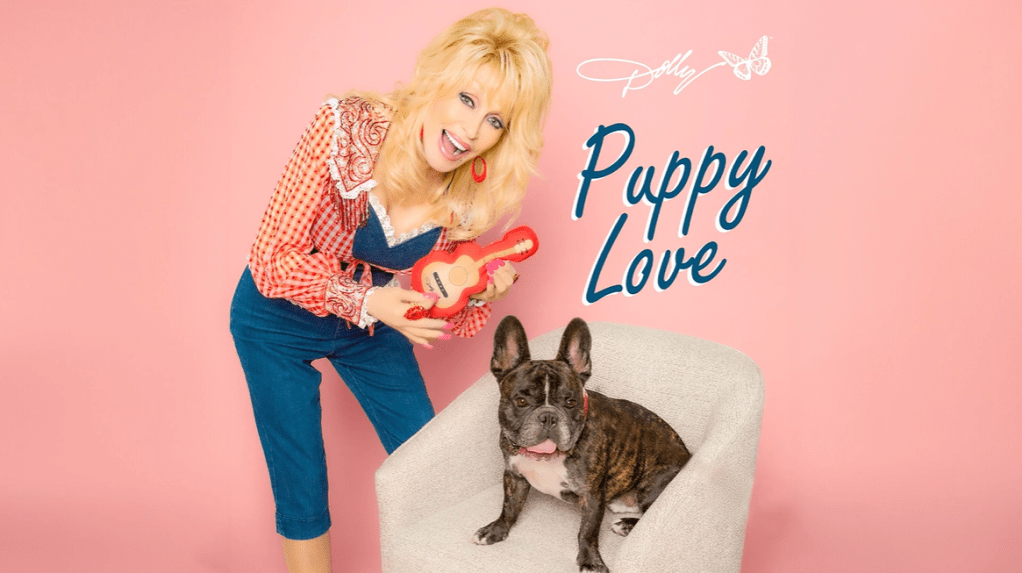 Cover for Dolly Parton's re-make of Puppy Love, as performed for her Pet Gala. Parton smiles as she "plays" a dog toy that looks like a guitar. Her dog, Billy, sits in the chair next to her.