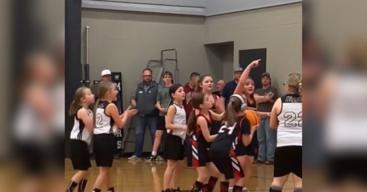 A girl with Down syndrome prepares to sink an important shot on the basketball court.