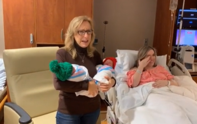 Grandma is excited to hold her surprise twin grandchildren. 