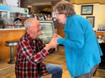 An elderly widower gets down on one knee to propose to his girlfriend. 