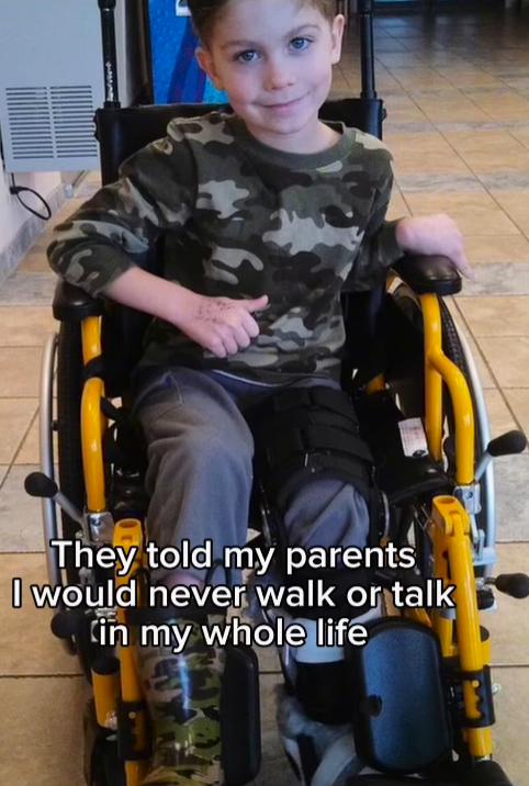hunter as a child sitting in a wheelchair. Text over the image says "They told my parents I would never walk or talk in my whole life:
