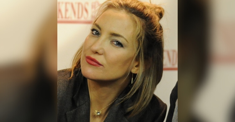 Close up of Kate Hudson at a book signing. She's smiling slightly as she tilts her head.