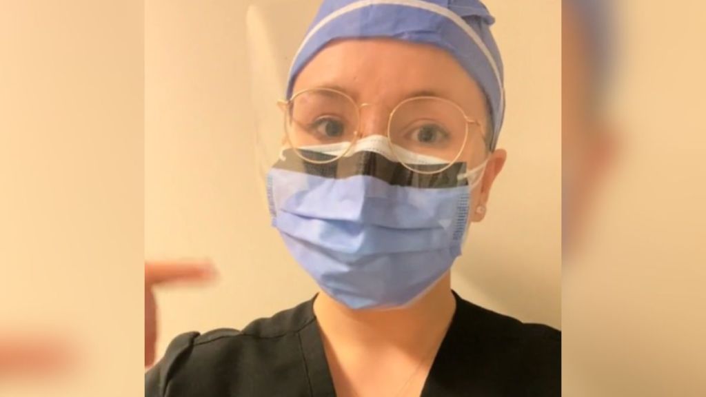 A med student with cancer wears a surgical cap and mask.