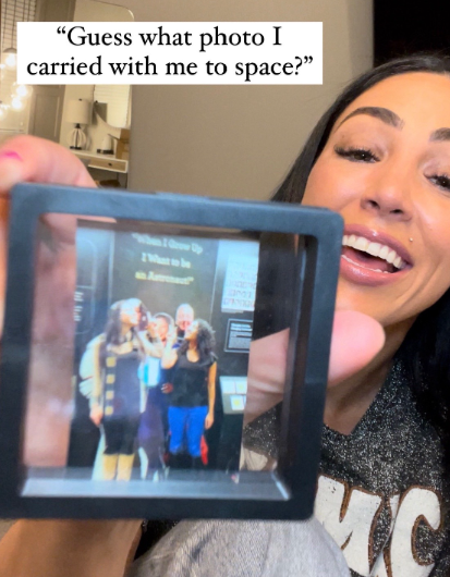 An astronaut shows the photo she brought with her to space.