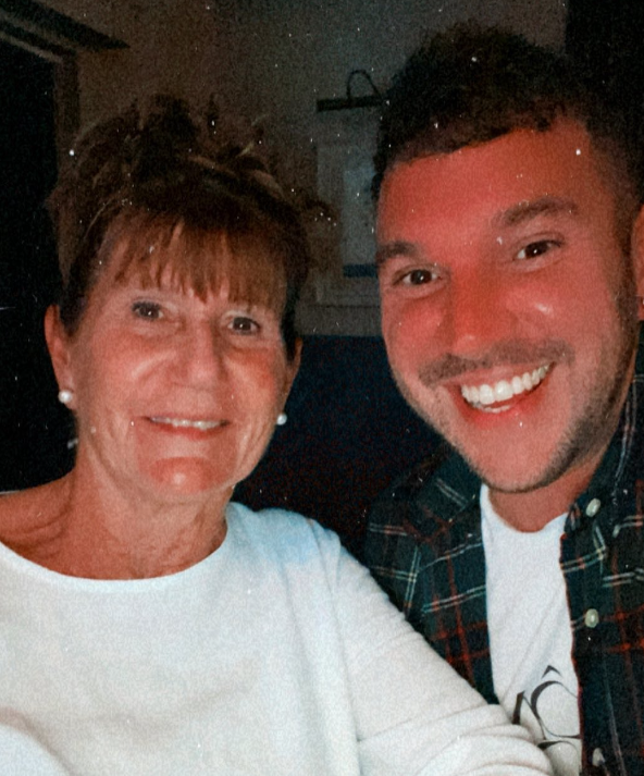 A woman named Julie and her son, Joe Cousins, smile for a selfie together.