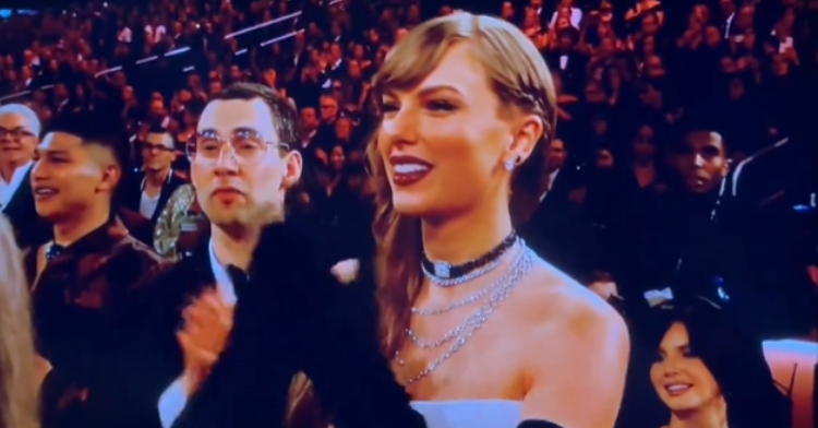 Taylor Swift smiles wide as she claps for Miley Cyrus at the Grammys.