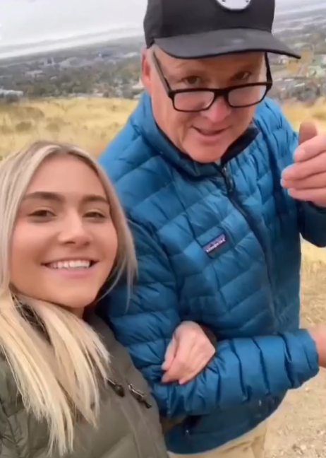 A woman takes a walk with her dad on a scenic trail.