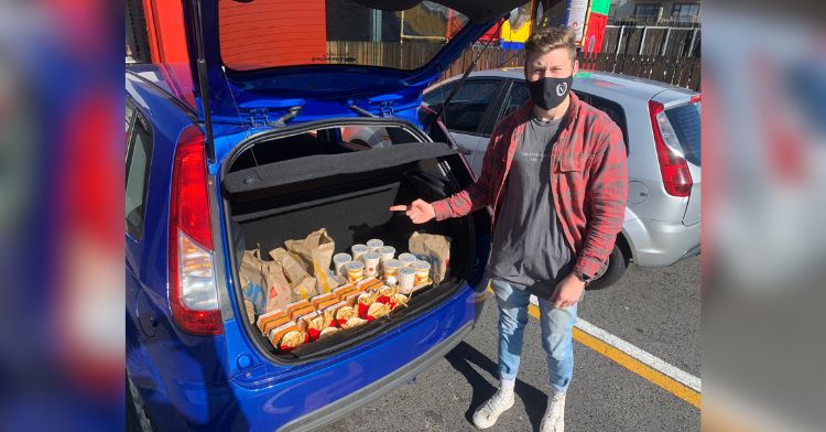 A man poses with 10 Big Mac meals in the trunk of his car.