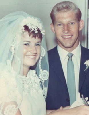 Old wedding photo of Jim and Maureen. They're both smiling as they stand next to each other.