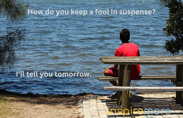 Image shows a person sitting at a picnic table on a summer day facing a body of water with the words, "How do you keep a fool in suspense? I'll tell you tomorrow."