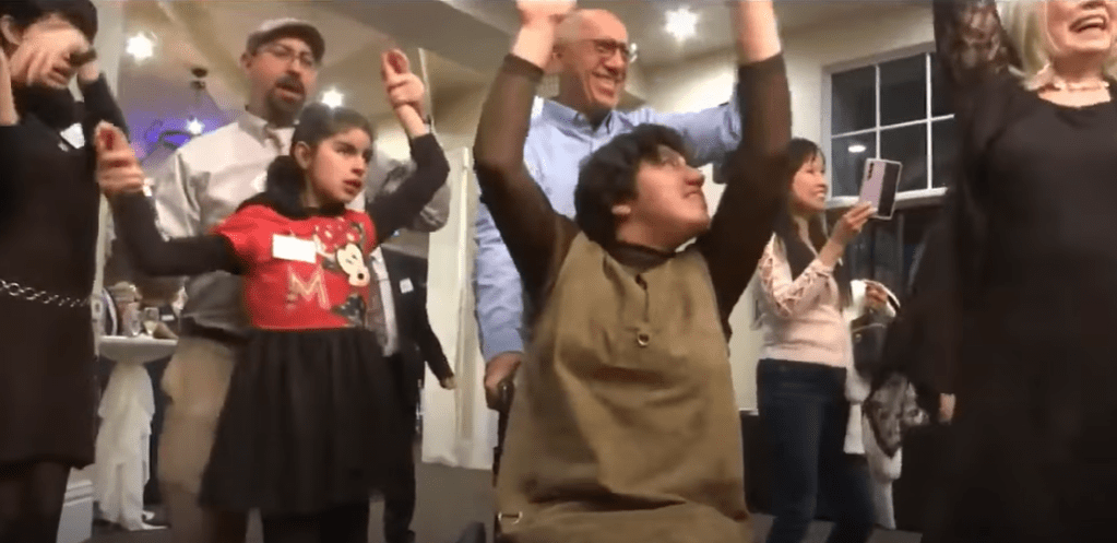 A group of folks with Parents Helping Parents dance at the reception location of the bride who called off her wedding.