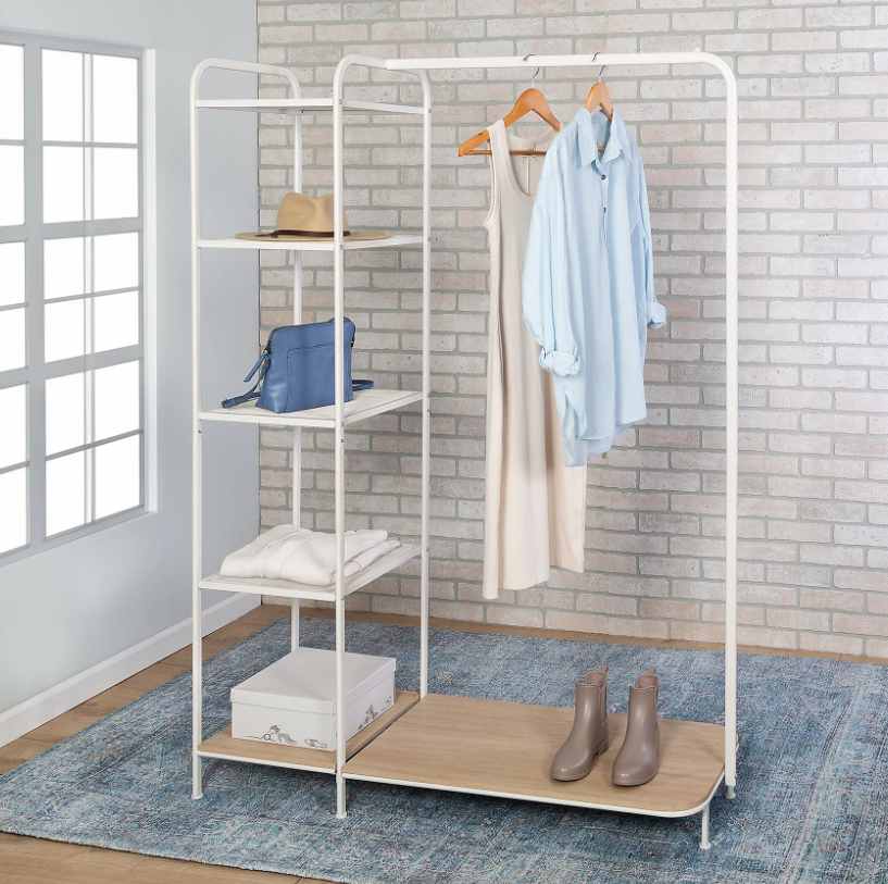 An organized white clothing rack in a bedroom.
