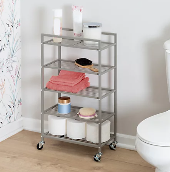 A rolling cart in the bathroom carrying personal care items.