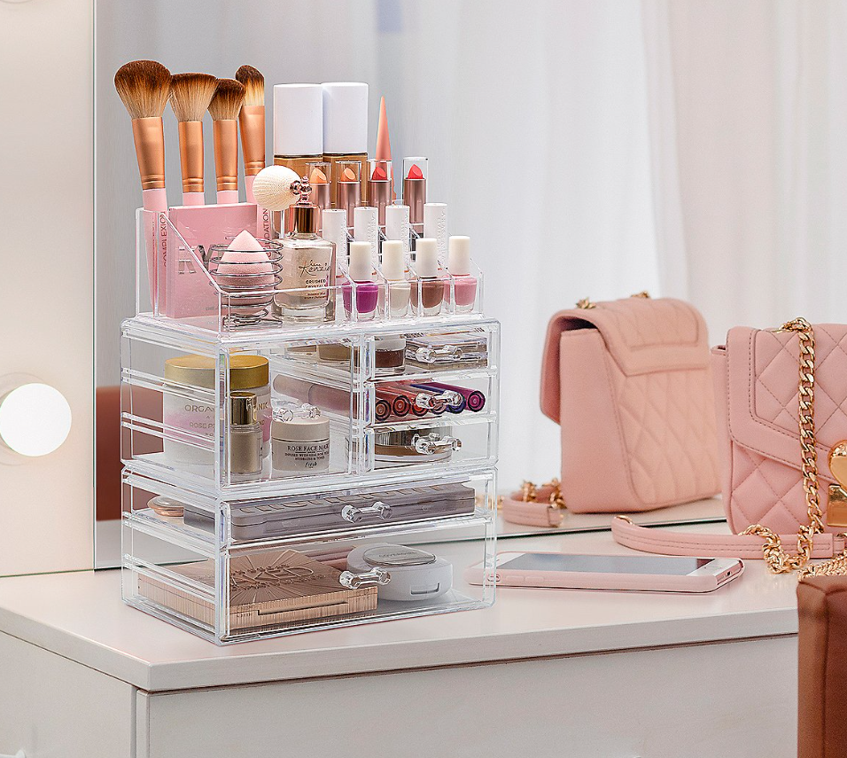 A clear jewelry box filled with organized makeup products.