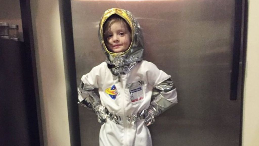 A little girl wearing an astronaut outfit.