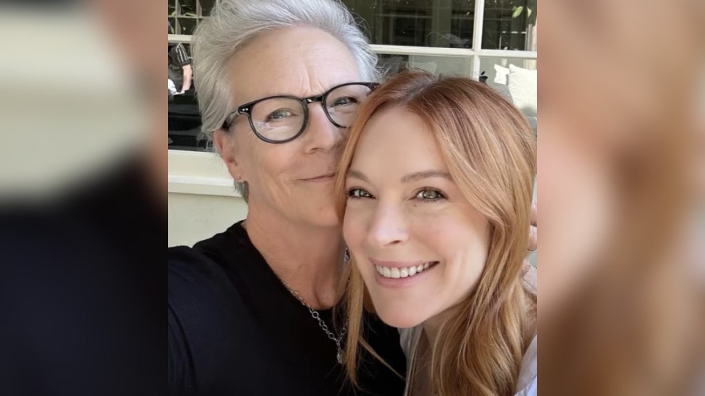 Jamie Lee Curtis and Lindsay Lohan smile as they take a selfie.
