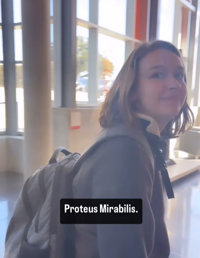 A young woman with a backpack says "Proteus Mirabilis."