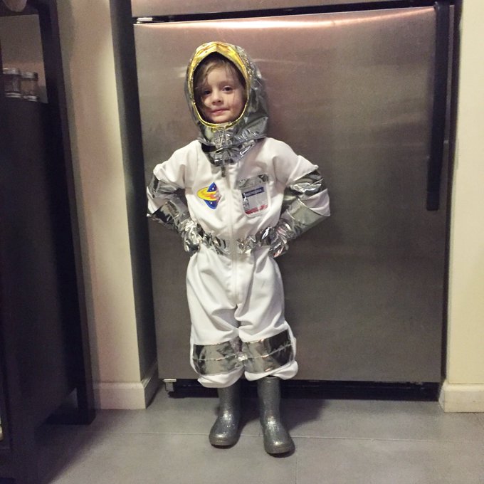 A little girl wearing an astronaut outfit.