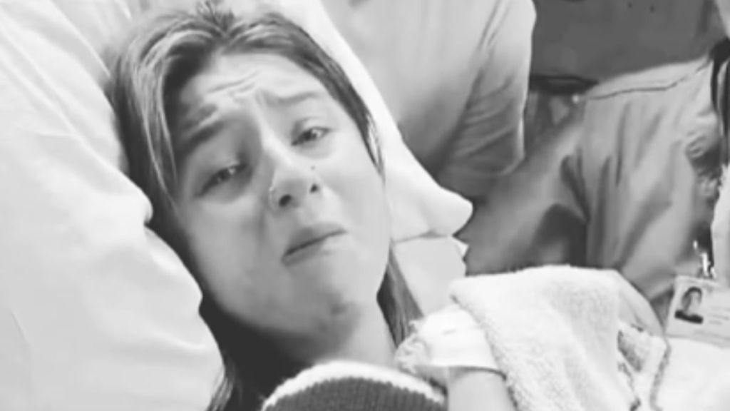 A mom is overcome with emotion as she holds her baby in the hospital.