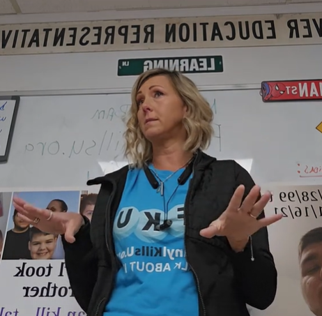 A woman gives a talk about overdose prevention in a classroom.