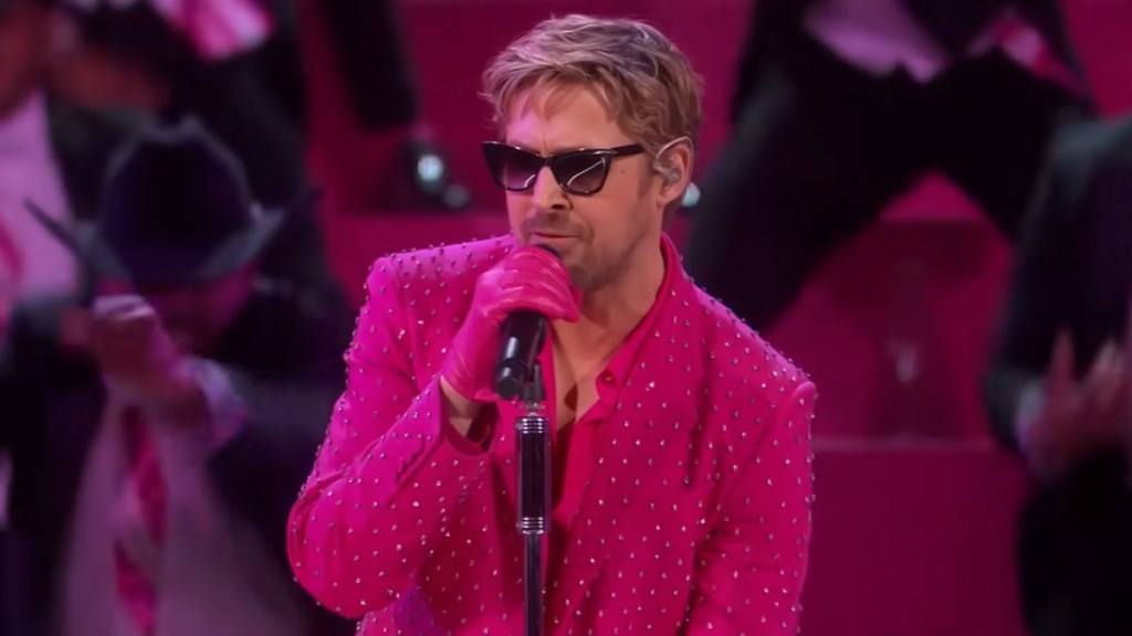Ryan Gosling wears sunglasses as he sings into a mic for his Oscars performance of "I'm Just Ken."