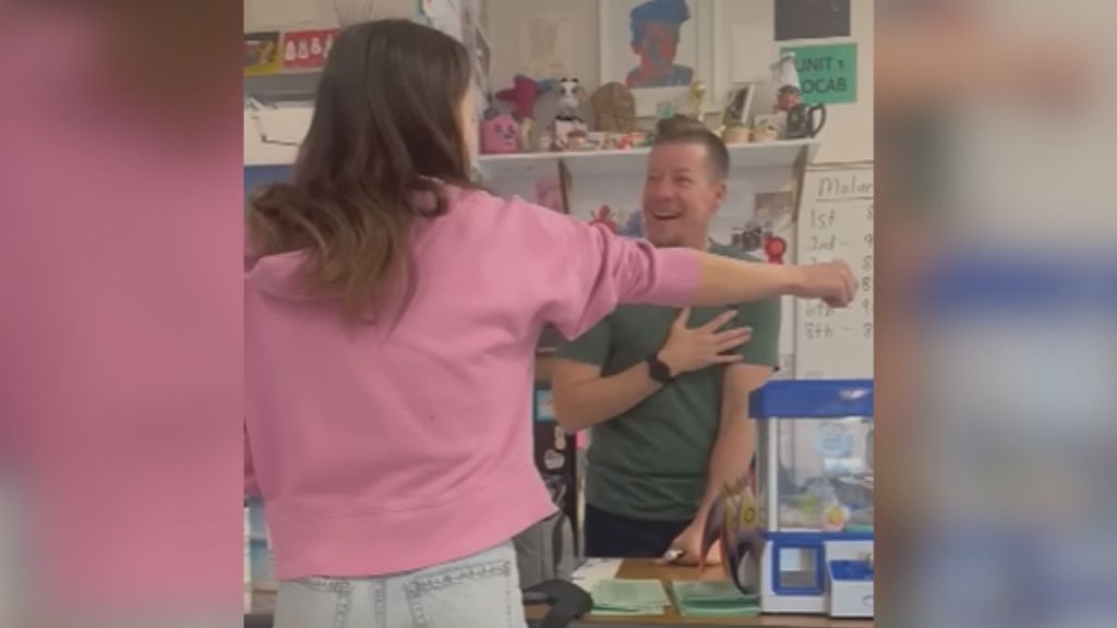 A student shows off her new tattoo to her teacher.