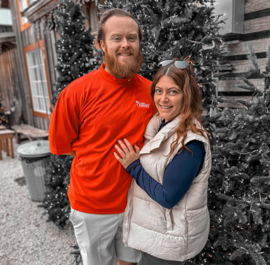 Emily Harris and Jake McDaniel smile as the pose together outside.