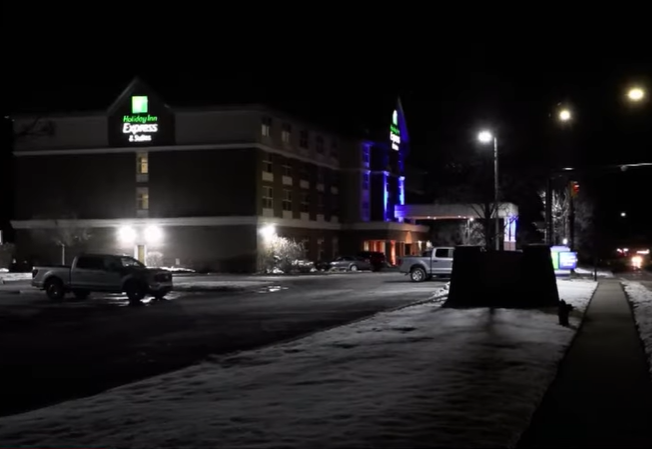 From a distance, an exterior view at night of a Holiday In Express & Suites in Utah.