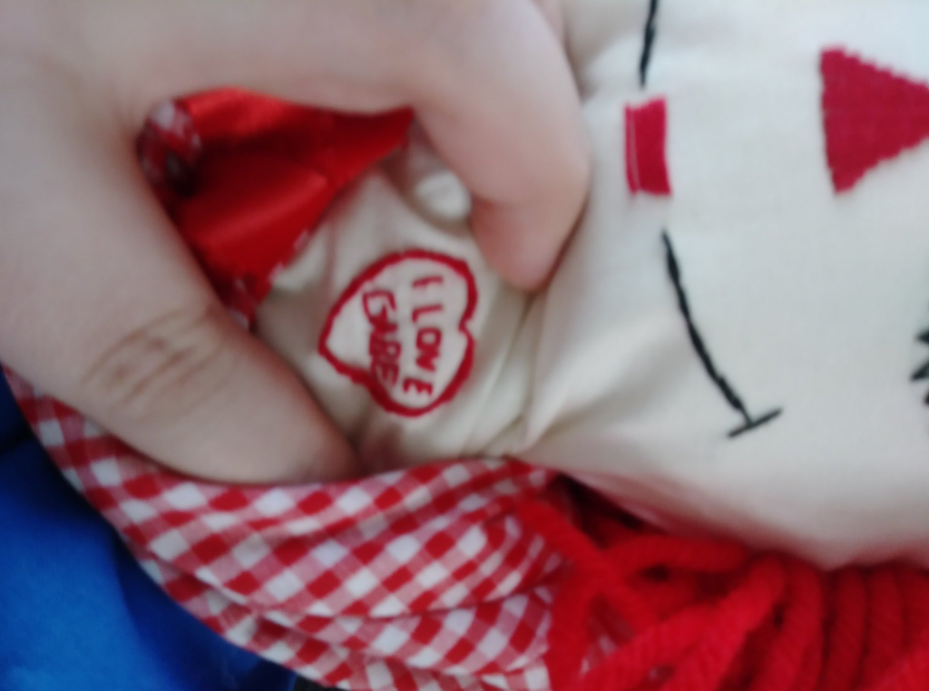 Close up of the altered Raggedy Ann trans grandchild, Gabe, got for Christmas. A stitched heart surrounds words that say: I love Gabe.