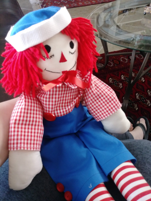 An altered Raggedy Ann doll sits on Gabe's lap.