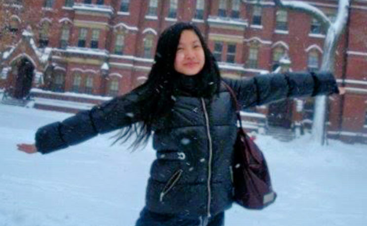 Amanda Nguyen smiles, arms out as she poses outside in the snow.