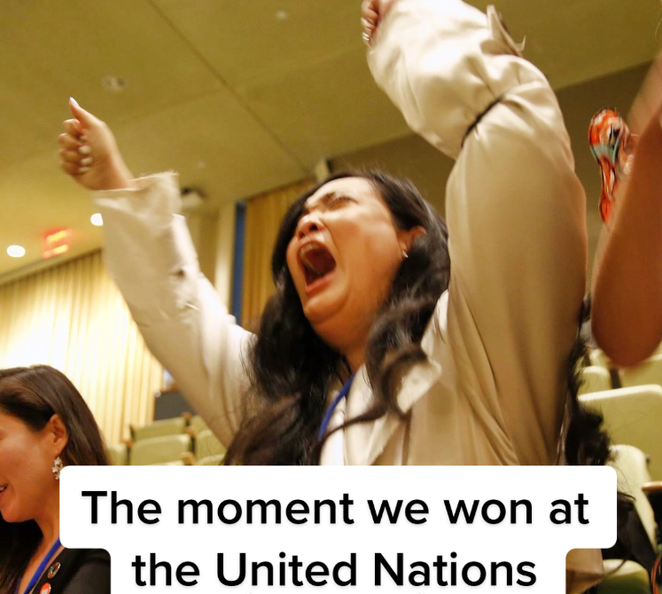 Amanda Nguyen raises her arms in celebration. Her eyes are closed as she cheers, mouth open wide. Text on the image reads: The moment we won at the United Nations.
