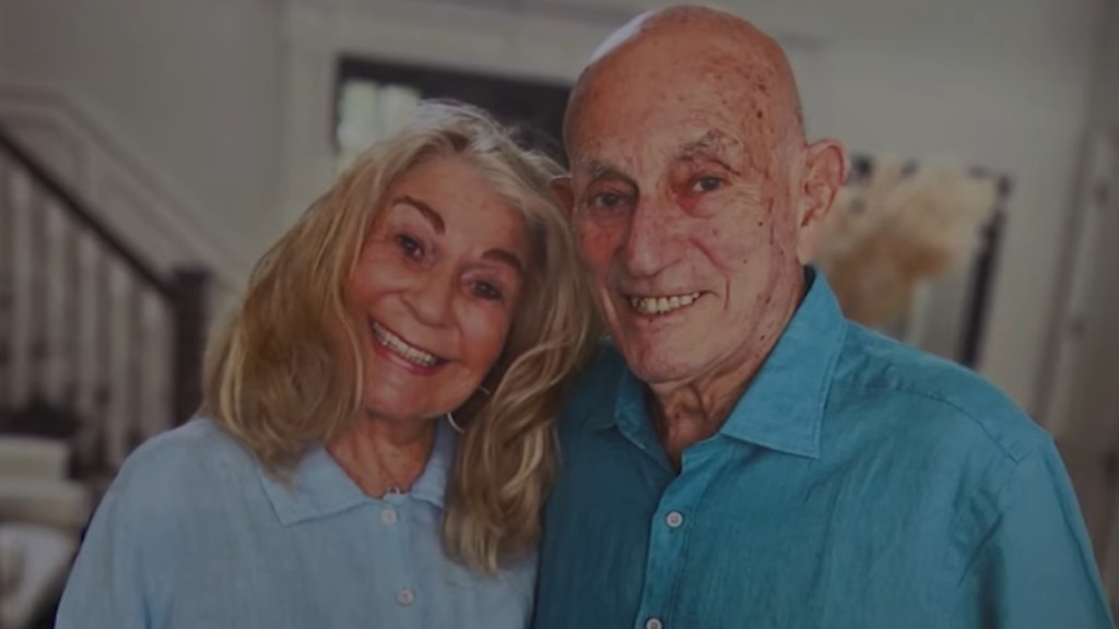 Harold and Jeanne smile as they pose for a photo together inside of a home.
