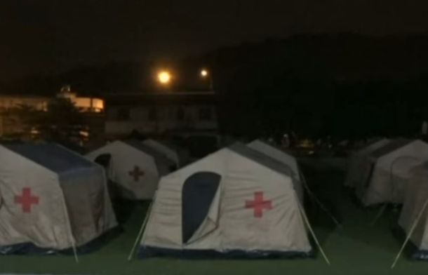 Image shows a temporary "tent city" set up to house displaced people.