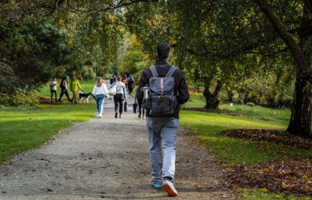 Stock image shows people walking along a path in a park.