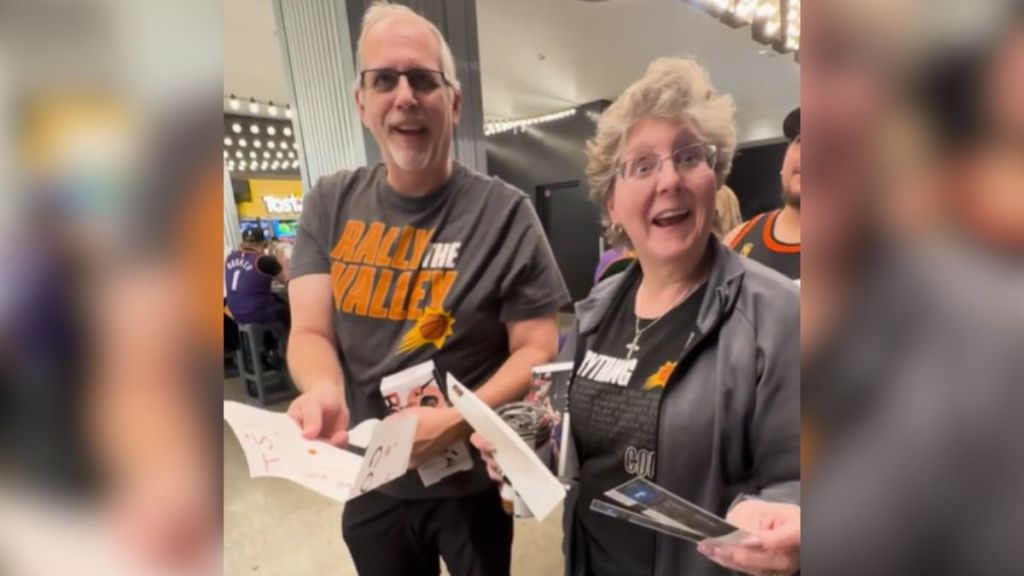 An elderly couple looks excited when they receive upgraded Phoenix Suns tickets.