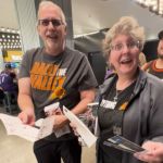 An elderly couple looks excited when they receive upgraded Phoenix Suns tickets.