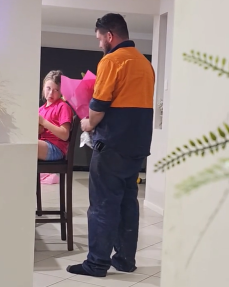 A dad brings a bouquet of flowers to his young daughter.