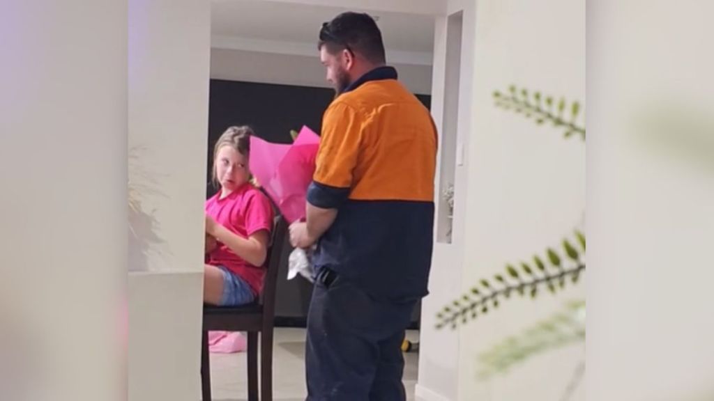 A dad brings a bouquet of flowers to his young daughter.