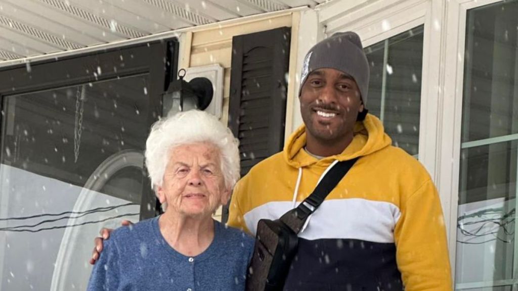 A man standing next to an elderly lady outdoors.