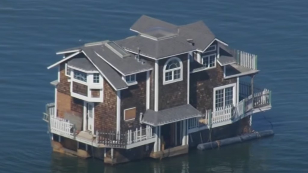 Close-up view of a two-story home floating down the San Francisco Bay.