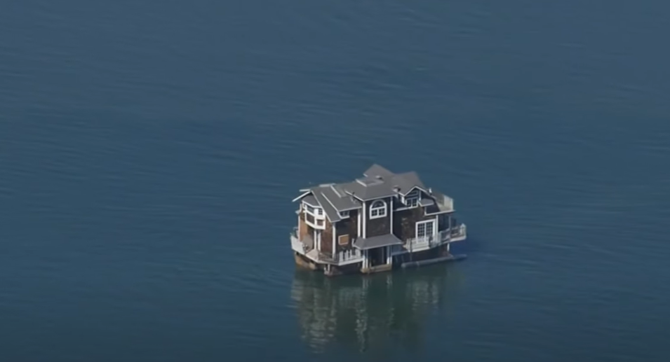 Distant view of a two-story home floating on the San Francisco Bay.