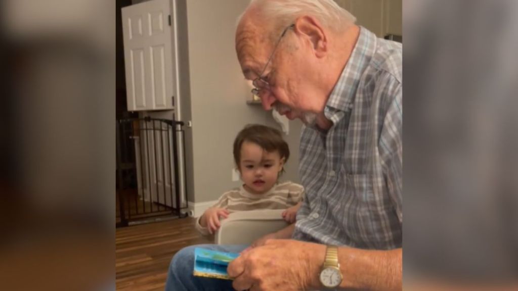 A great-grandpa reading out loud to a toddler.