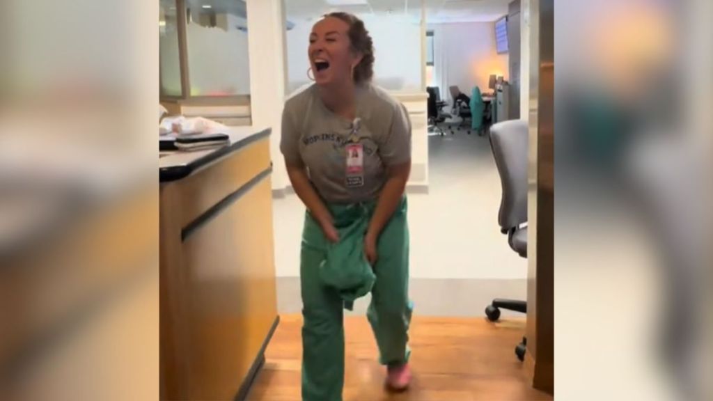 A nurse laughs in surprise at her workplace.