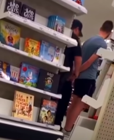 A young man is placed in handcuffs by police in Target.