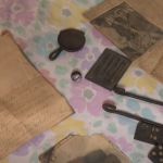 A time capsule with items like newspapers and a cast iron pan laid out.