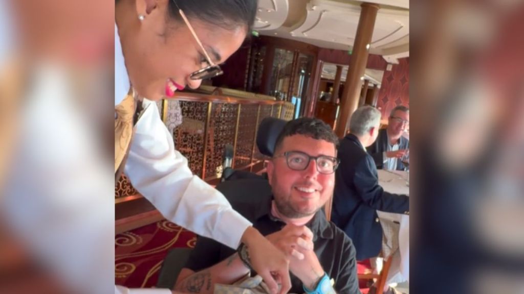 A waitress cuts up food for a diabled client on a Disney cruise.