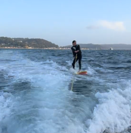 A person riding a wakeboard in the water.